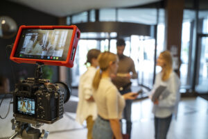 Team members connect through an internal company meeting, combining in-person collaboration with remote video conferencing.